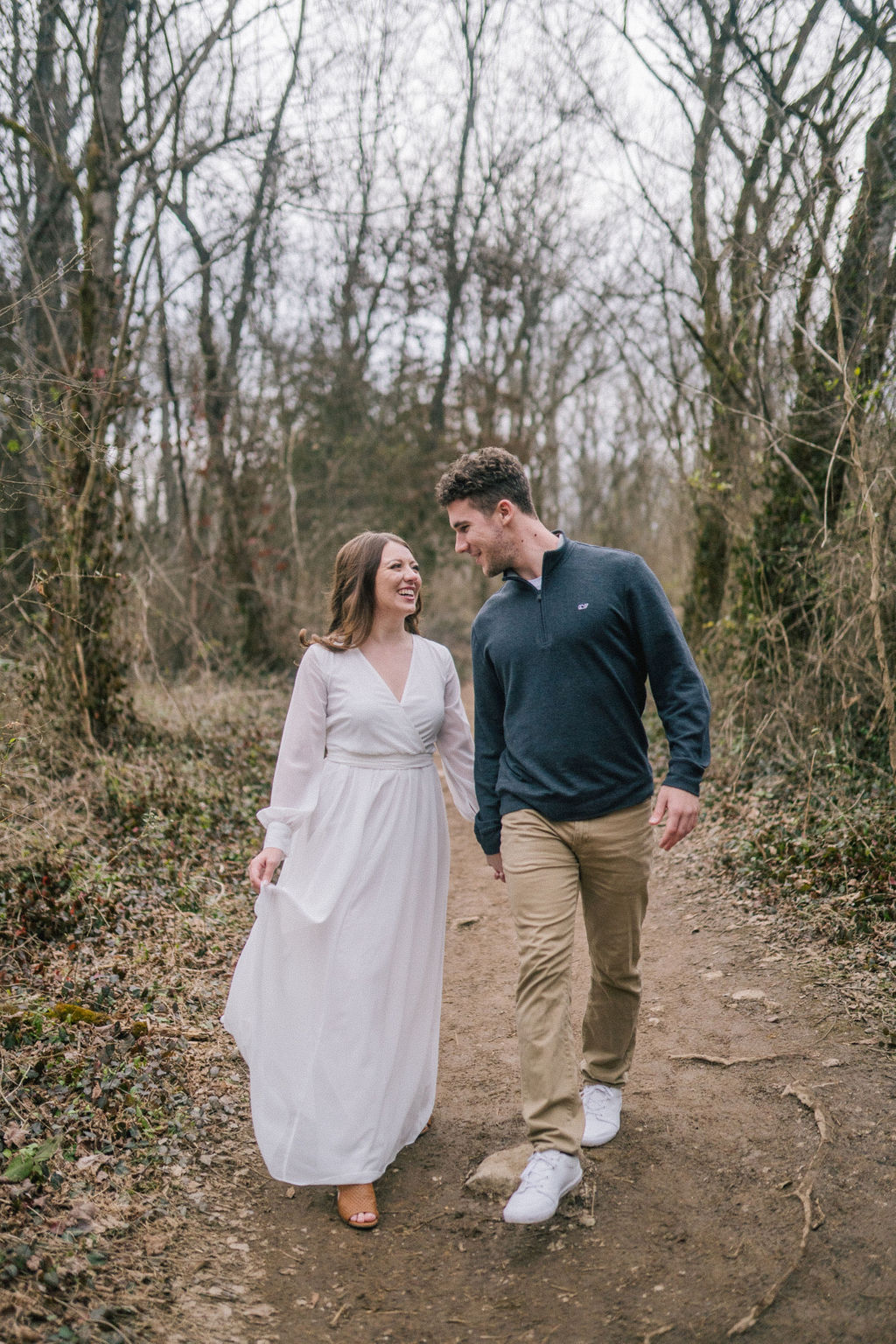 man and woman walking through forest laughing and talking