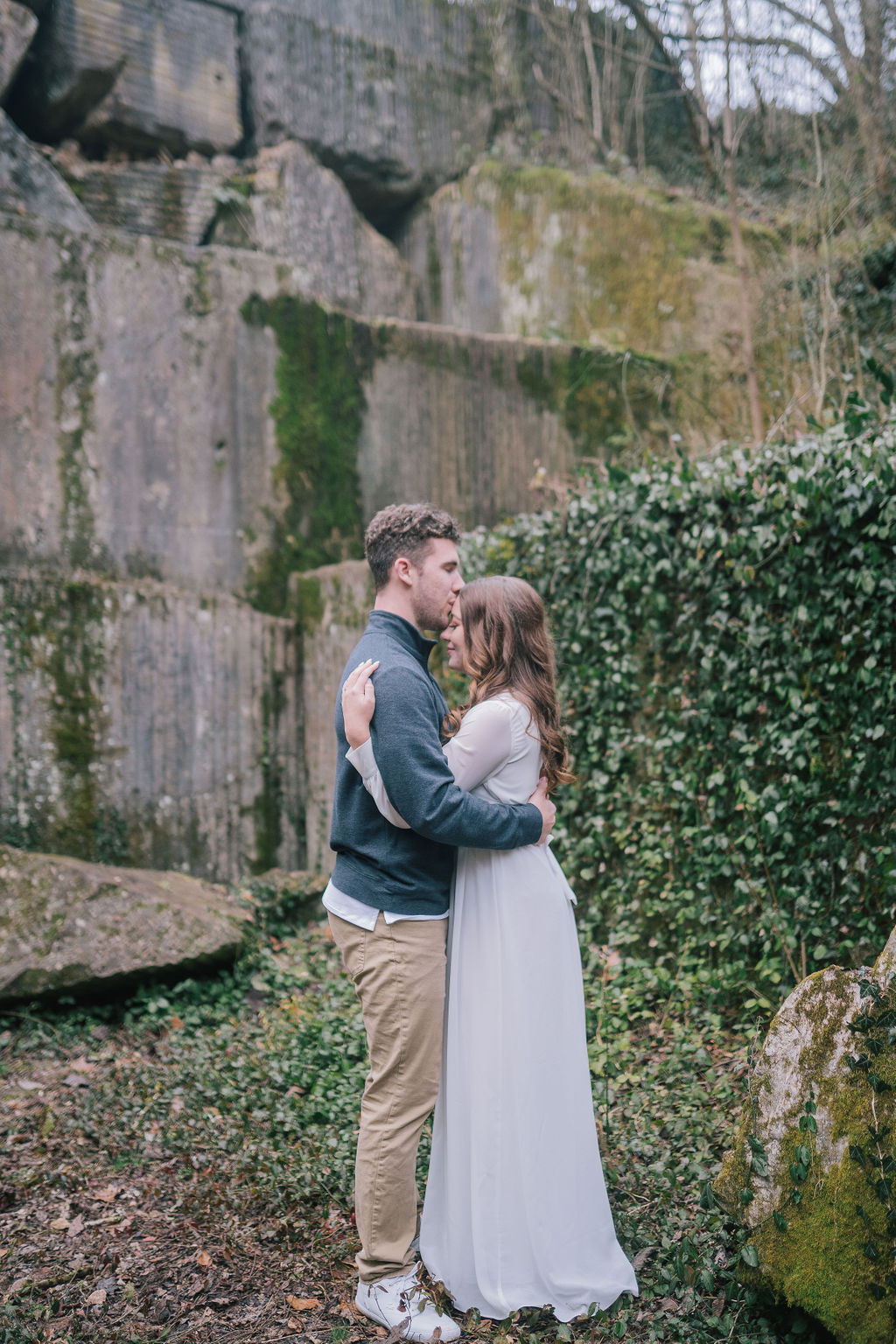 man and woman hugging in green field near meads quarry during outdoor engagement session