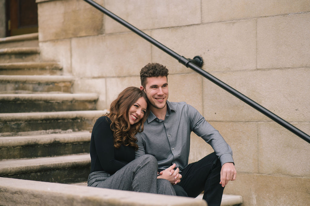 young engaged couple sitting on steps in downtown knoxville during knoxville engagements session
