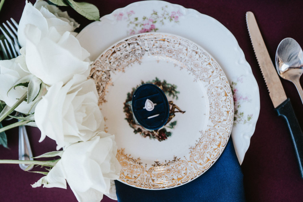 gorgeous wedding ring flat lay on vintage china table setting
