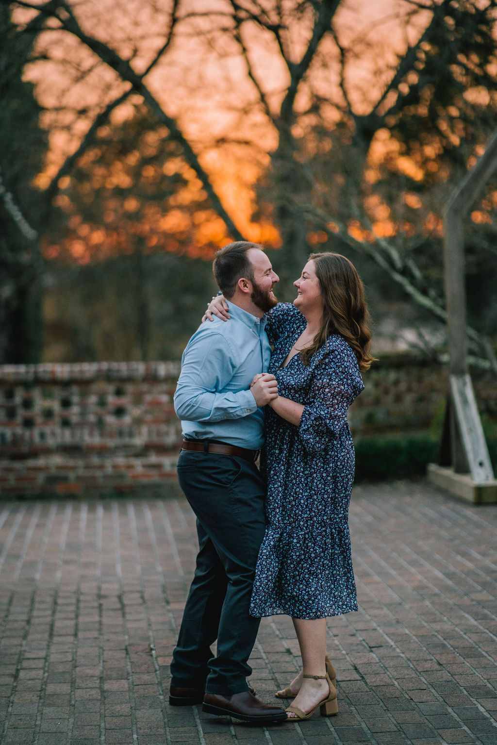 pigeon forge engagement session with man and woman dancing along on a stone porch at sunset