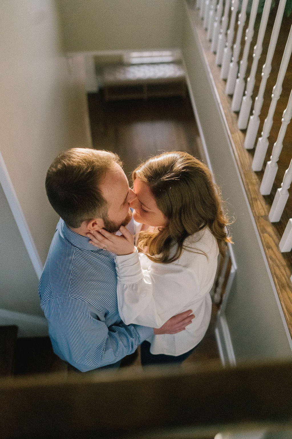 in home engagement session with the couple was on the stairs. Very romantic engagement photos