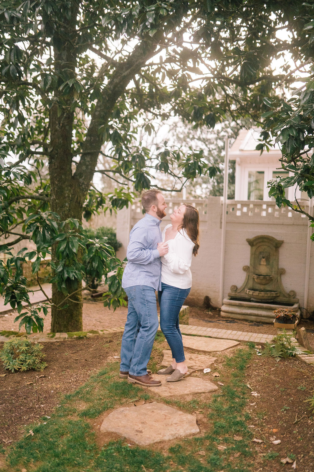 dancing in the garden together for an engagement session with southern charm