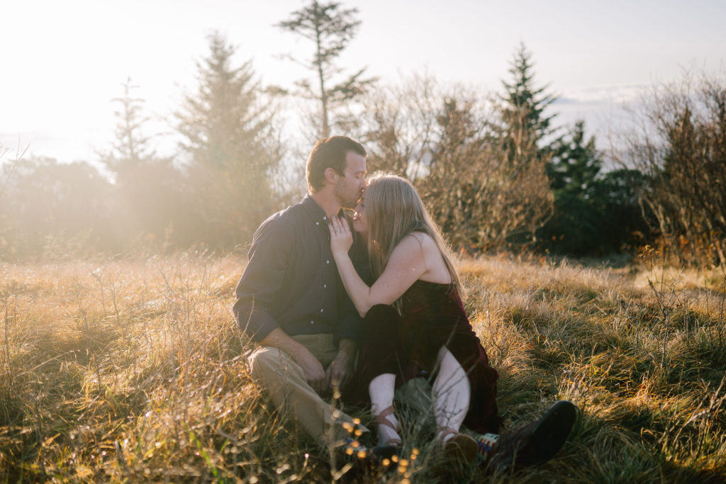 fall smoky mountain wedding on top of a mountain. Adventure photoshoot with bride and groom sitting in a golden field at sunset 