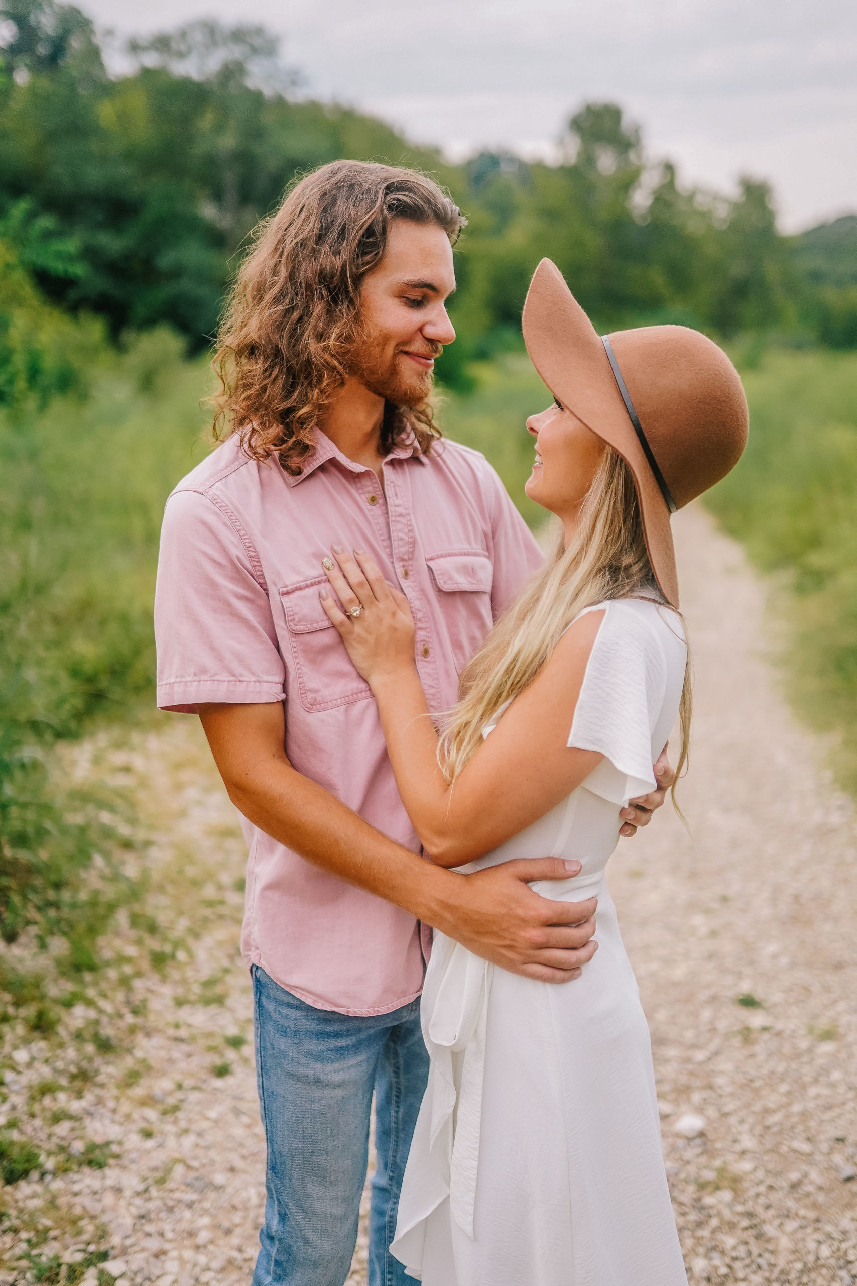 adventure session in the smoky mountains with a boho couple on their honeymoon. Couple standing on a dirt road holding each other.