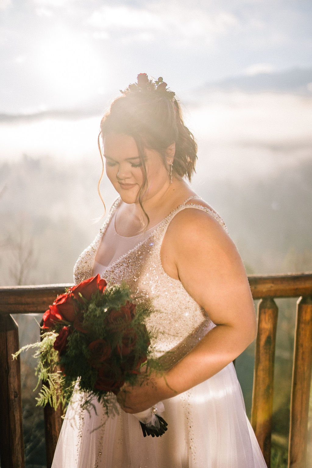 bride in the mountains surrounded by bright light wearing a white sparkly gown