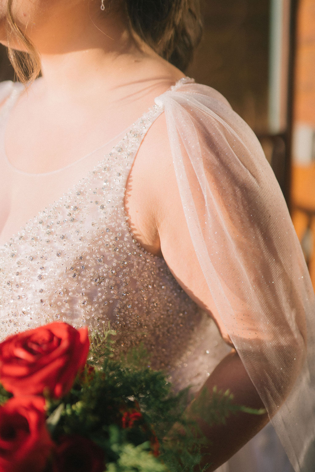 deatil shot of a brides sparkly cape attached to her shoulder