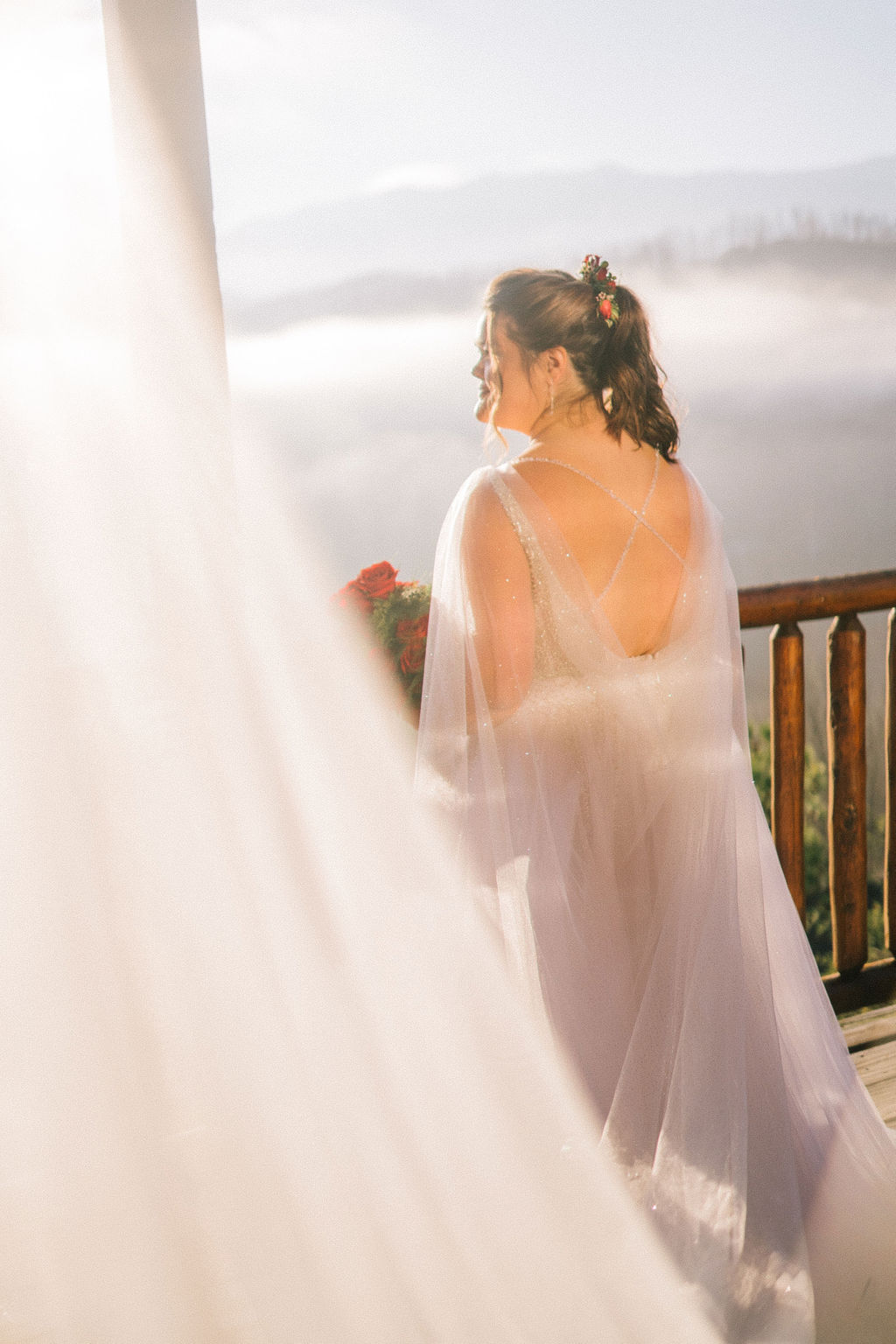 a bride on her wedding day in the Smoky Mountains standing on her balcony surrounded by fog