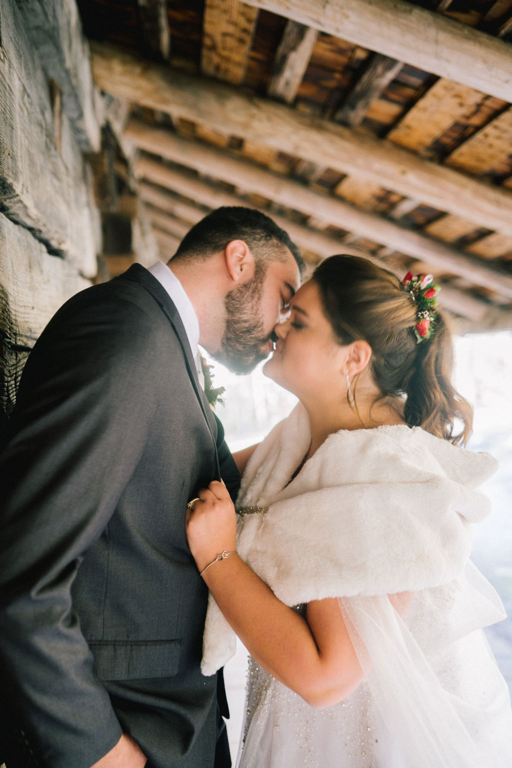 knoxville wedding photographerbride and groom elope in the smokies to a small cabin. They kiss each other outside of the cabin as the bright light shines through the image