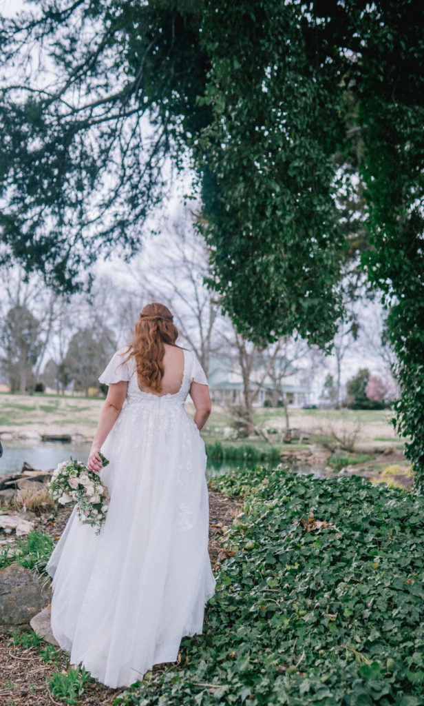 whimsical bride walking through the woods to a lake at Marblegate farm