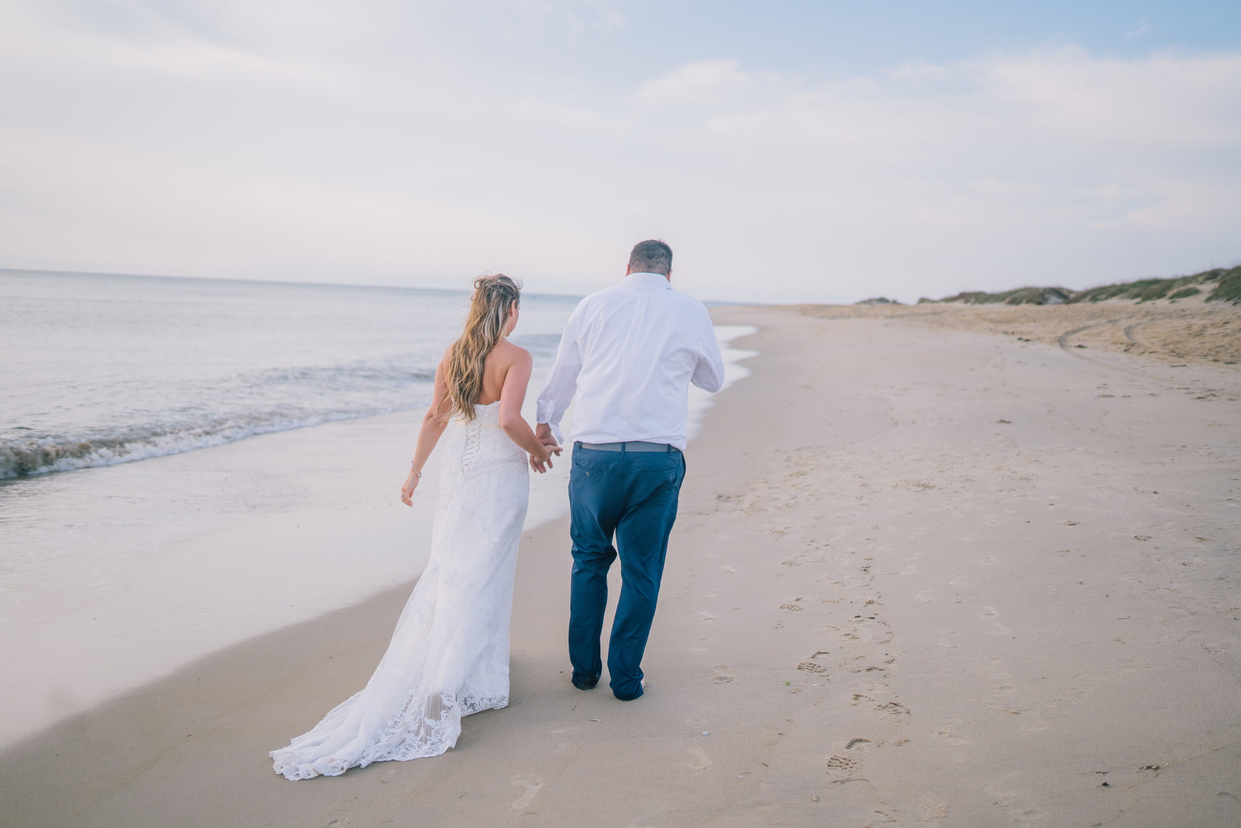 beach wedding at the outer banks, bride and groom walking along the shore line