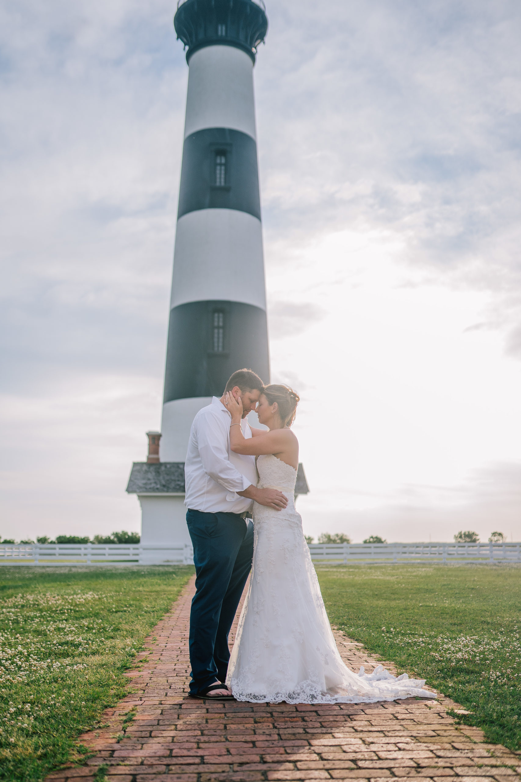 sunrise session with a light house on the beach for a wedding day shoot