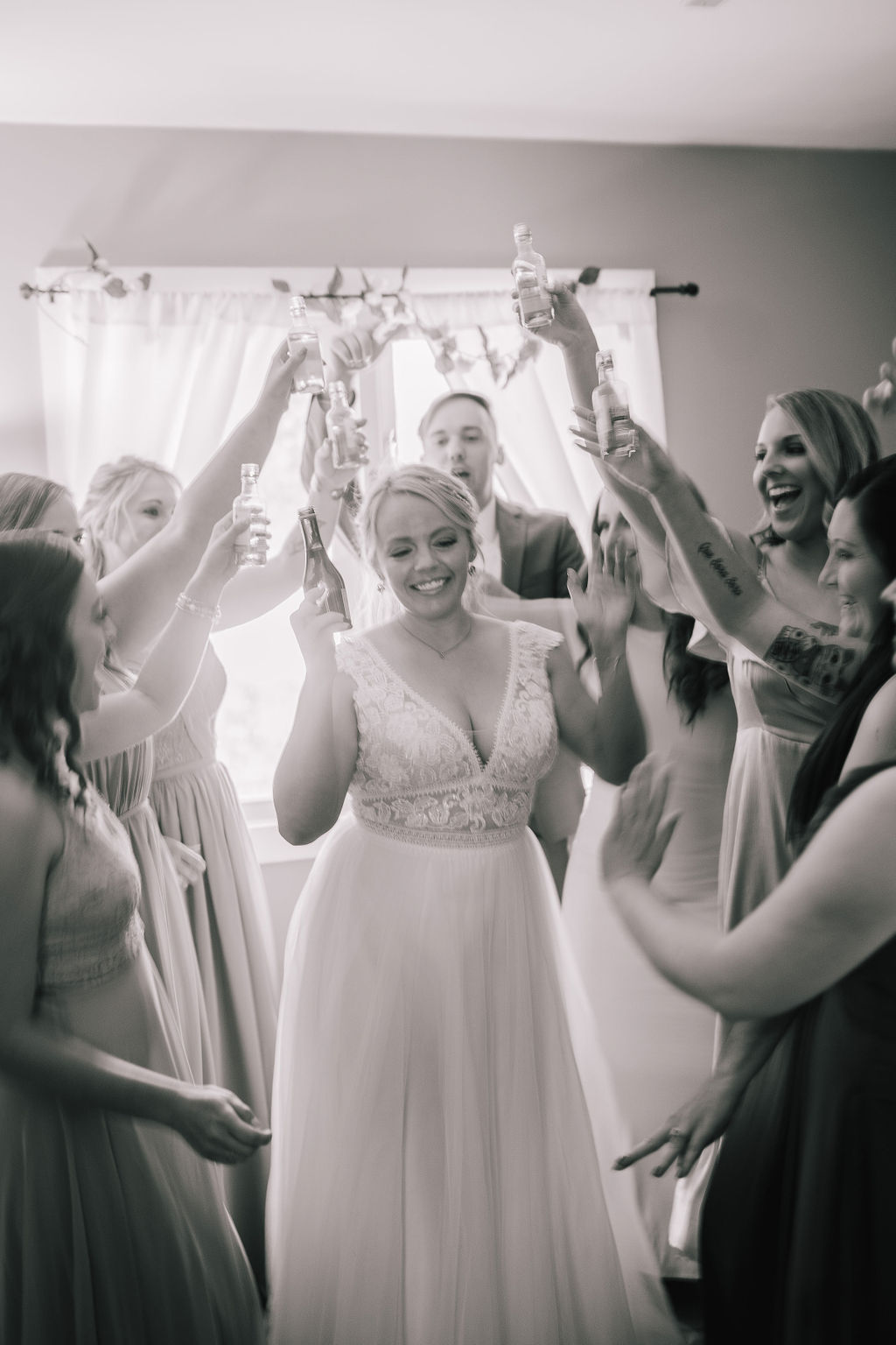 black and white photo of the bridal party havign a cheers befre the wedding