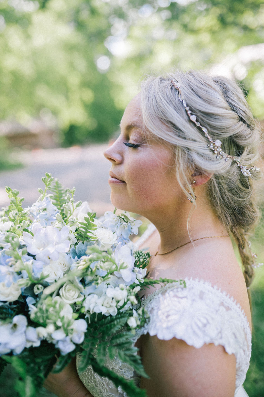 beautiful southern bride holding a white and green bouquet up to her face as she closes her eyes and smiles
