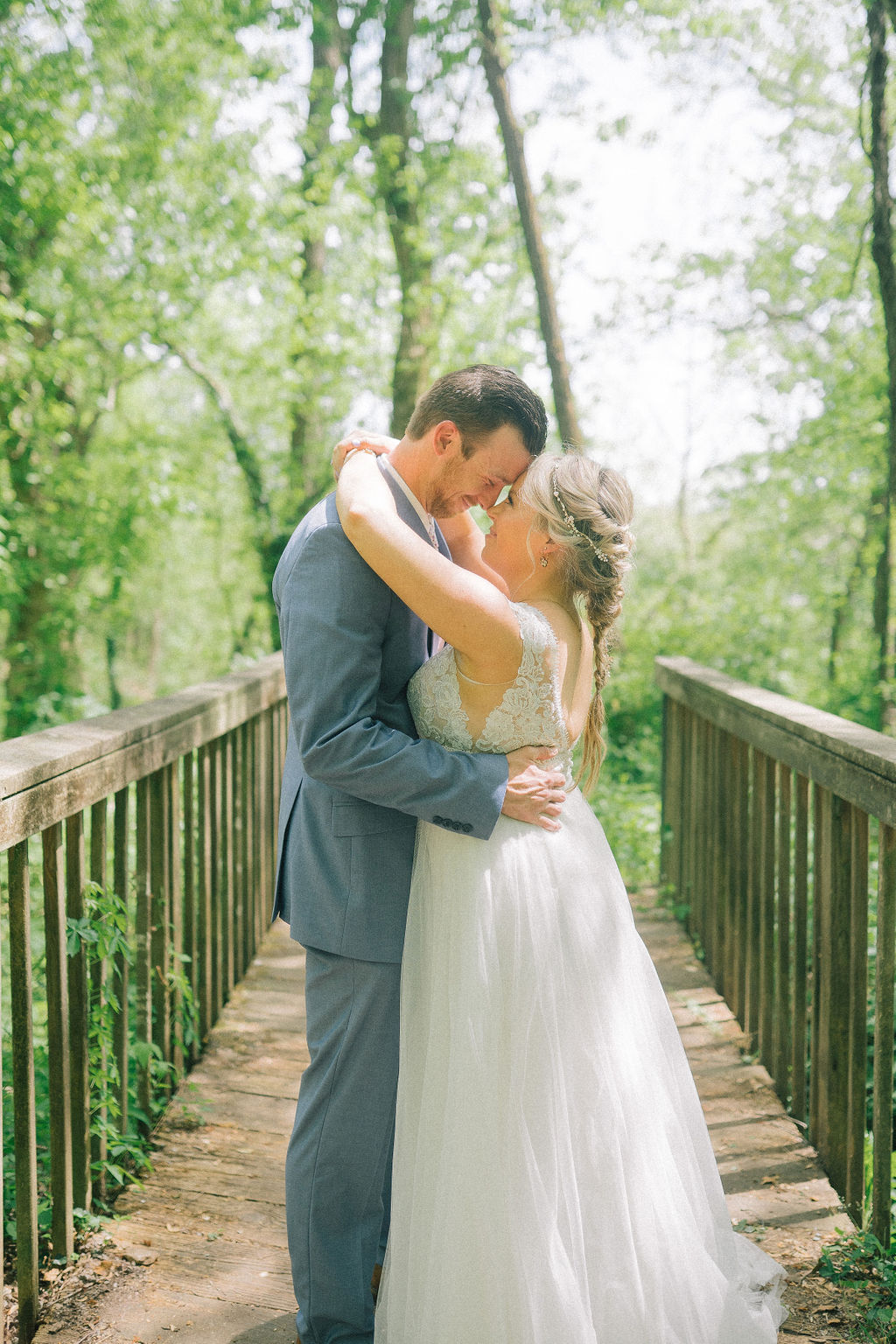 bride and groom embracing each other in the woods of the Ijams on a bridge