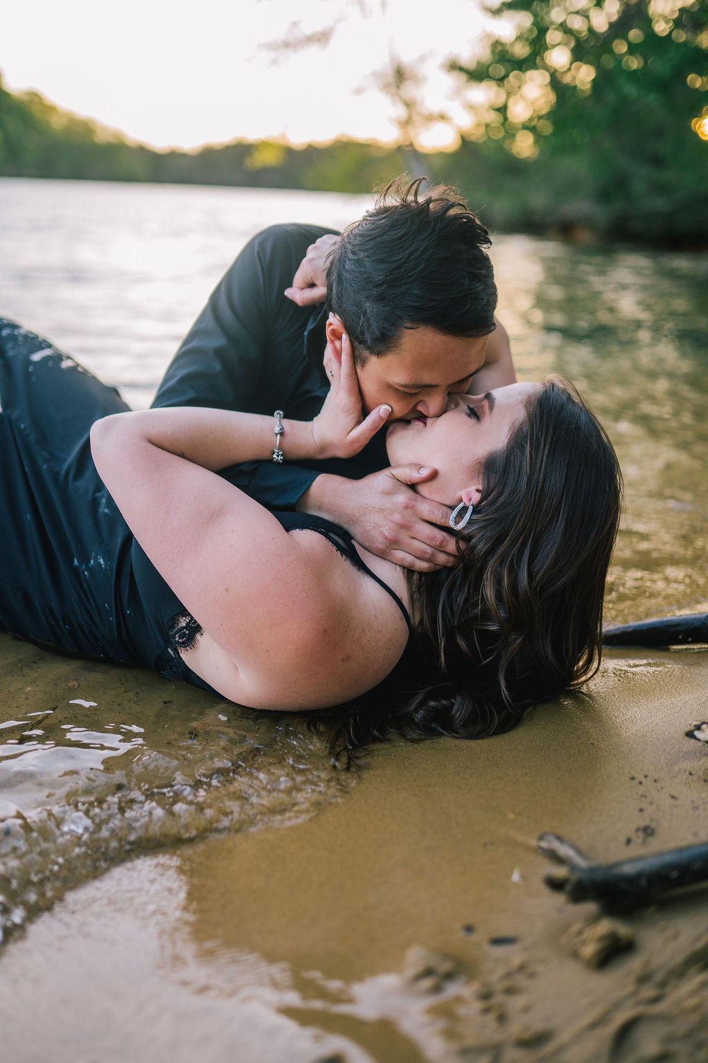 Meads Quarry Tennessee engagement session in the water with man and woman laying down and making out on the beach of Meads Quarry while wearing black
