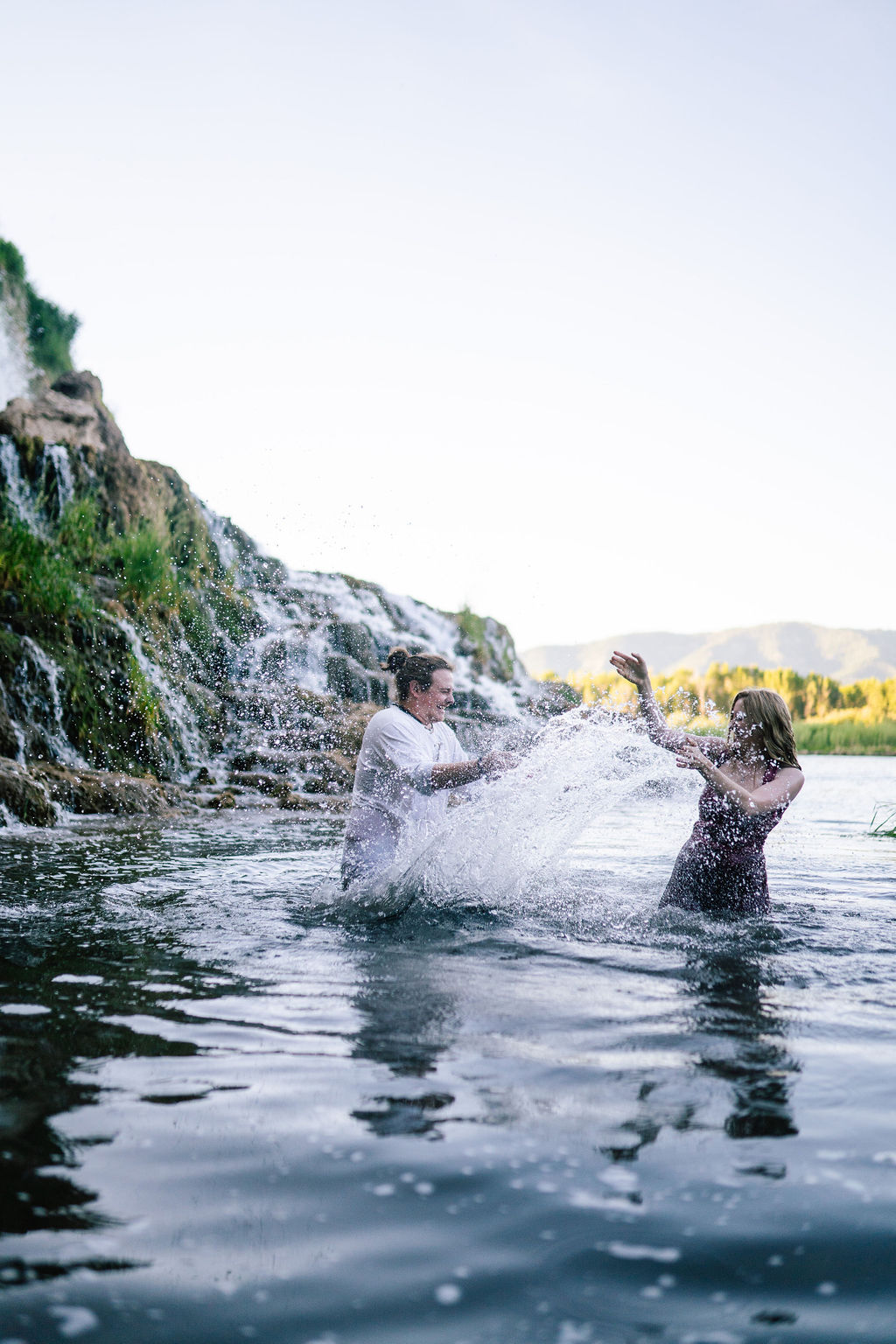 mand an womand splashing around in a lake in Tennessee for their Knoxville adventure engagement session