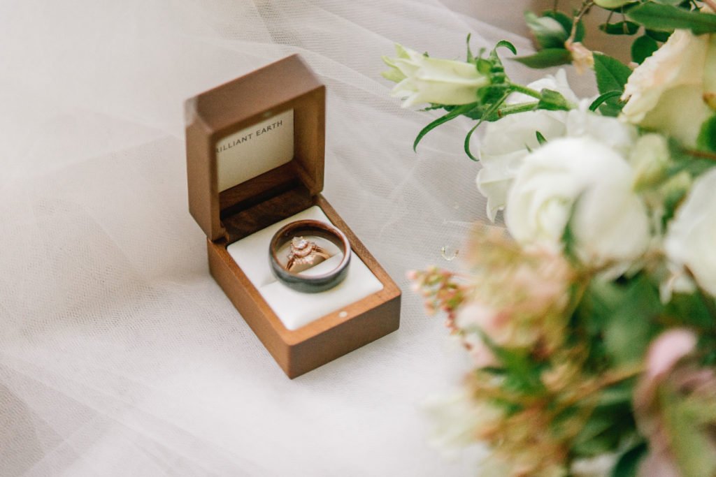 wedding rings in a wooden box, sitting on a veil with some florals for a Knoxville wedding day