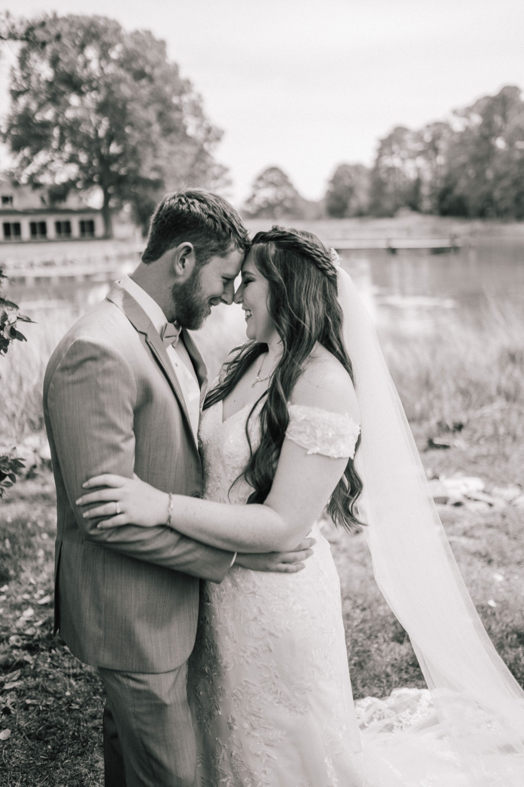 black and white image of bride and groom embracing each other nextto a river at their wedding venue in Maryland