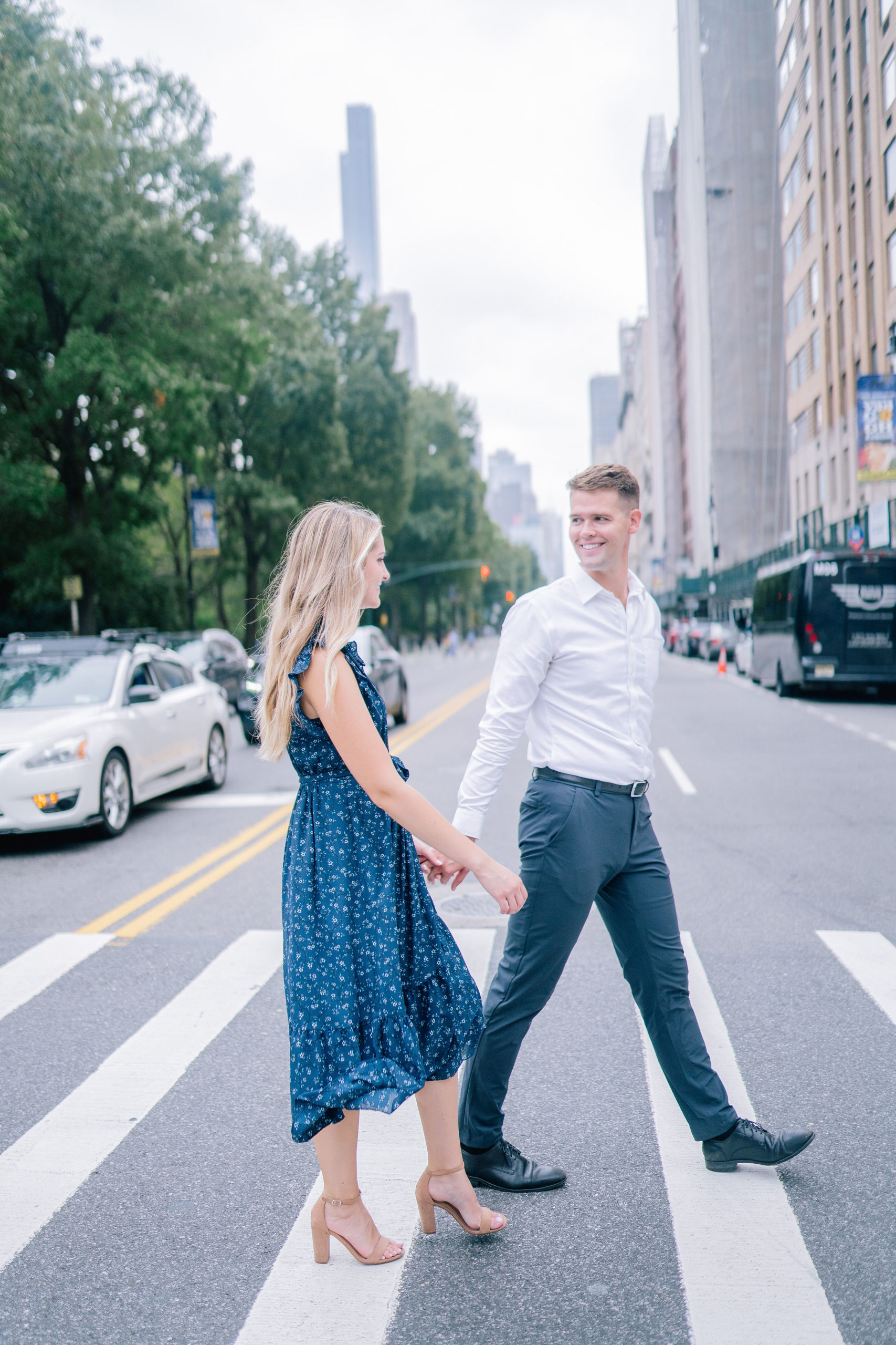 man and woman holding hands as they walk thorugh the strret of New York for their engagement session with the best Manhattan wedding photographers