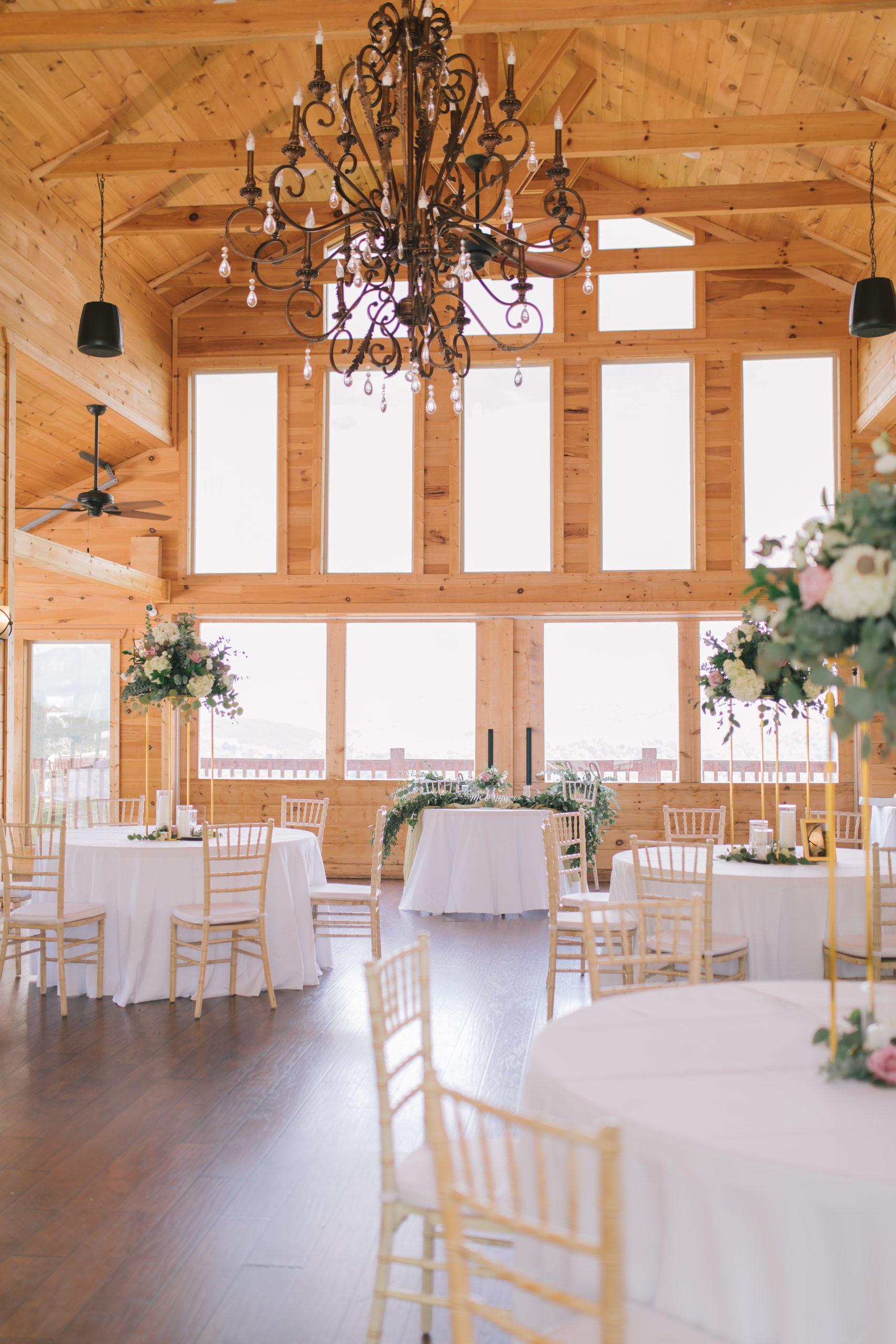 beautiful reception space at the Magnolia with tall elegant florals on each of the tables