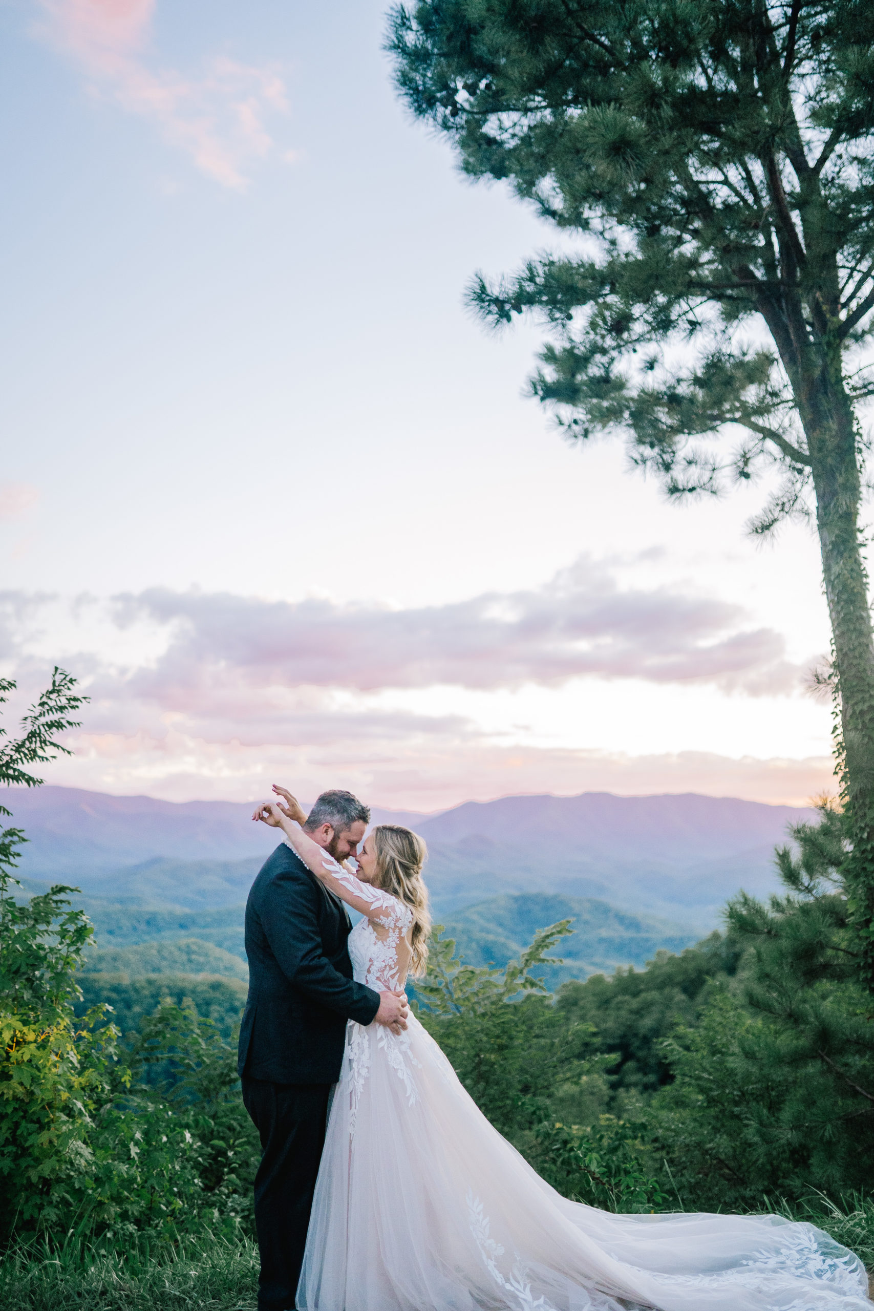 sunset wedding photos in Pigeon Forge at the Magnolia with bride and groom embracing each other on a mountain top in the Smokies